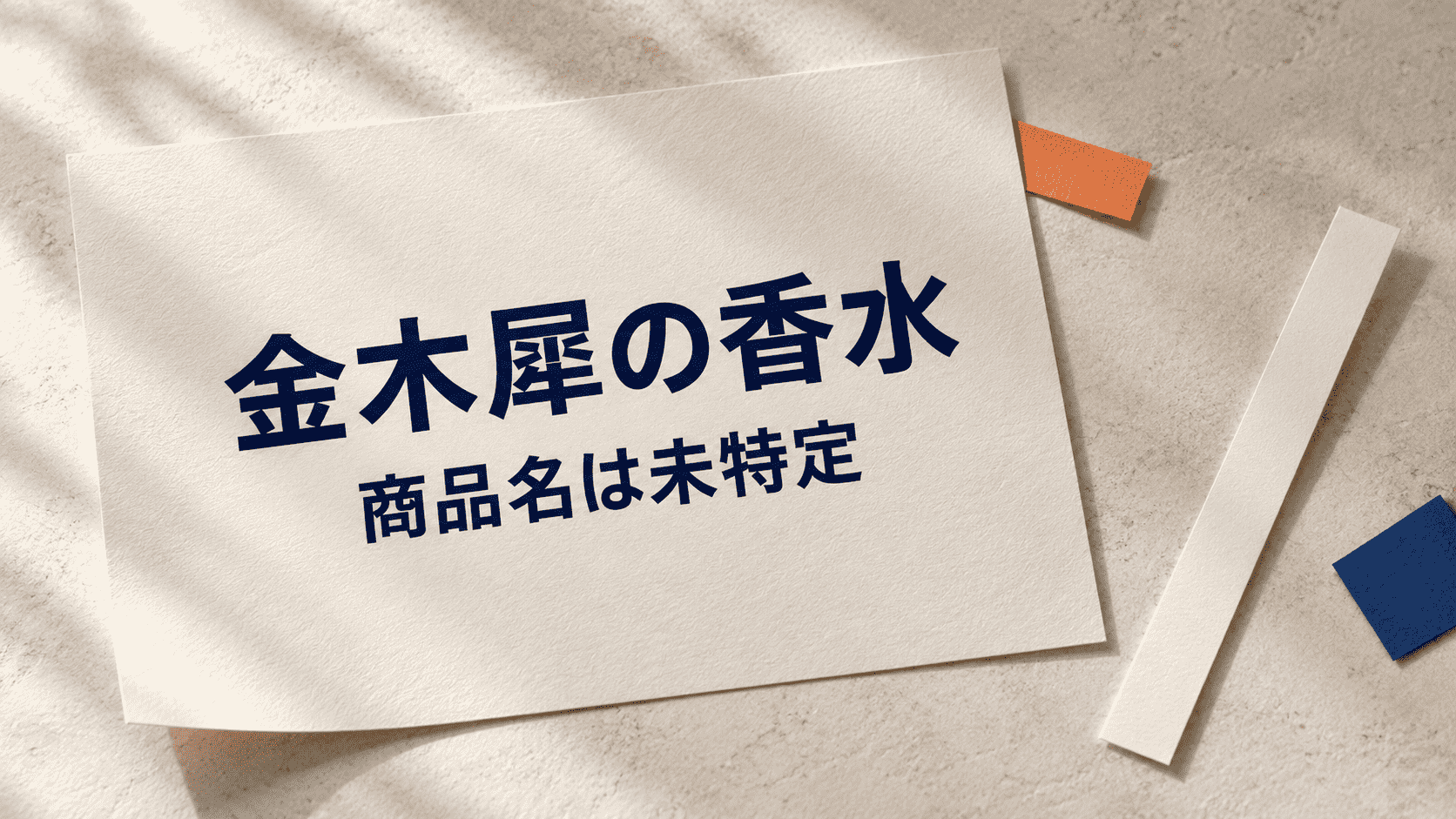「金木犀の香水 商品名は未特定」と印刷した紙と試香紙の静物イメージ
