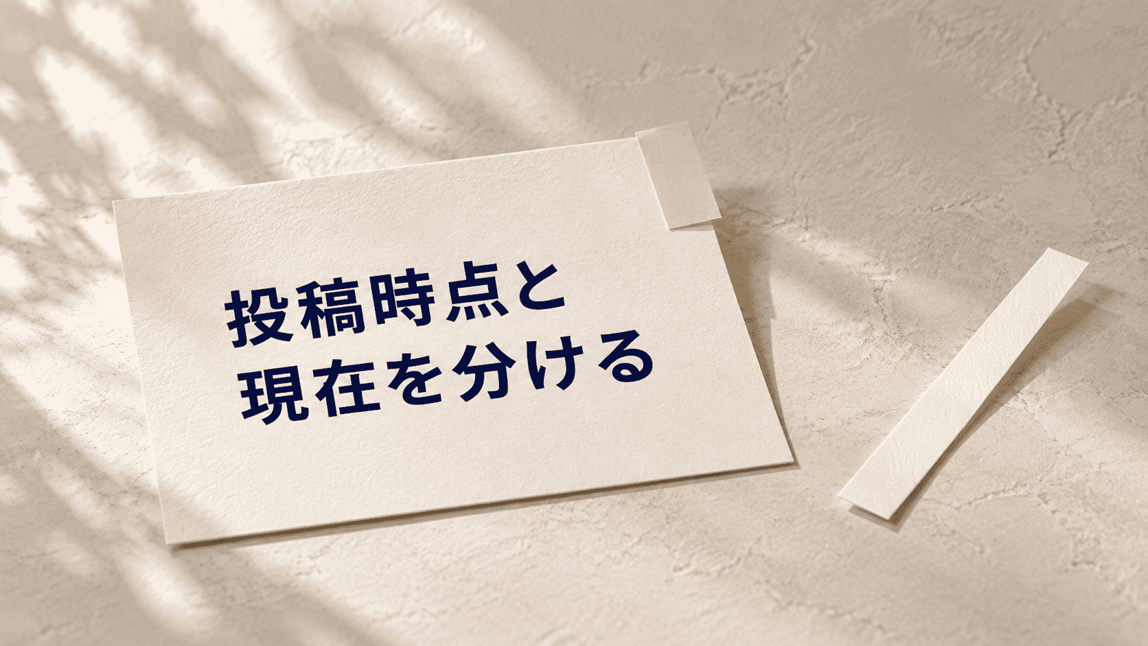 「投稿時点と 現在を分ける」と印刷した紙と淡い黄色の紙タブの静物イメージ