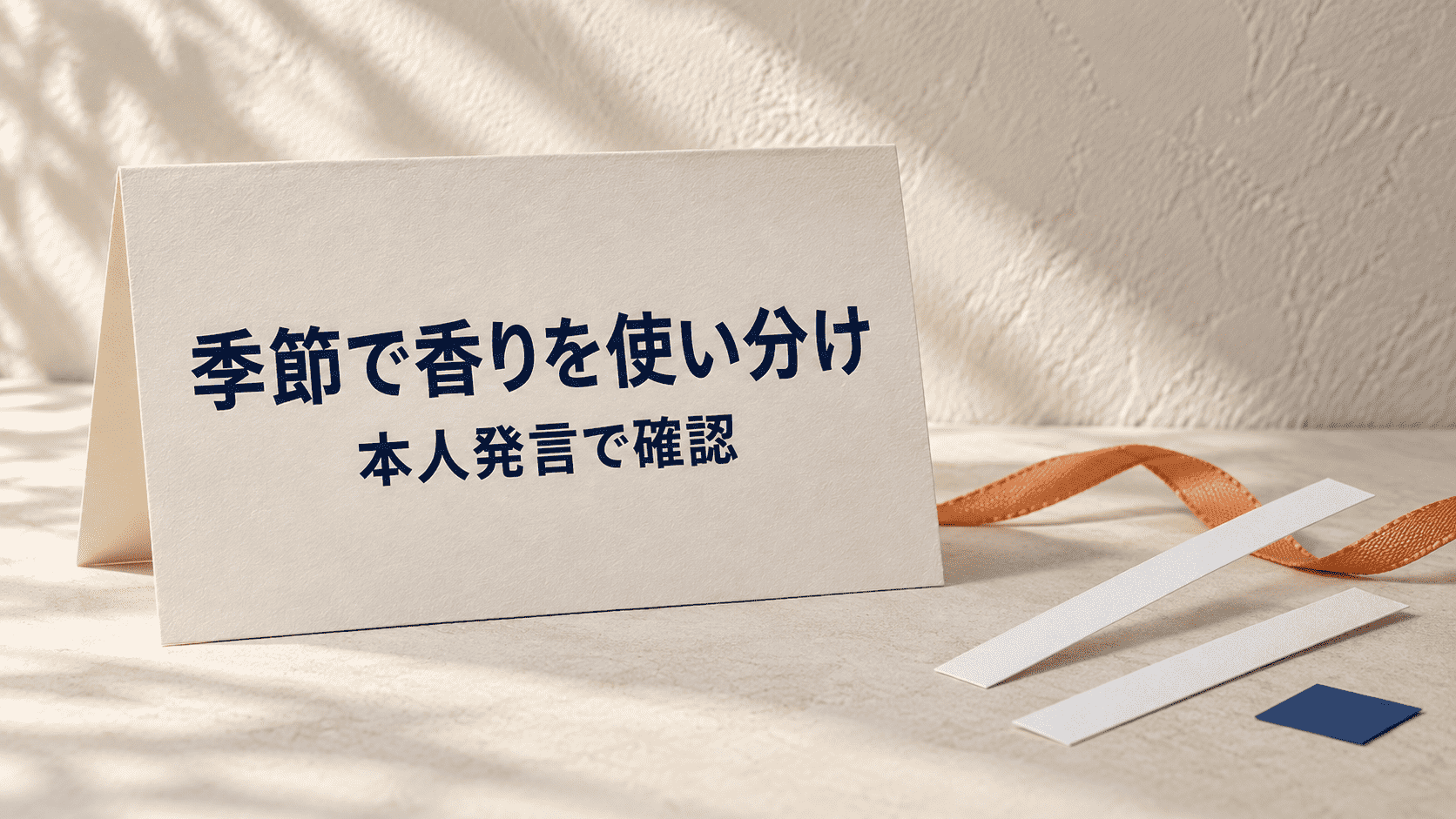 「季節で香りを使い分け 本人発言で確認」と印刷したカードと試香紙の静物イメージ