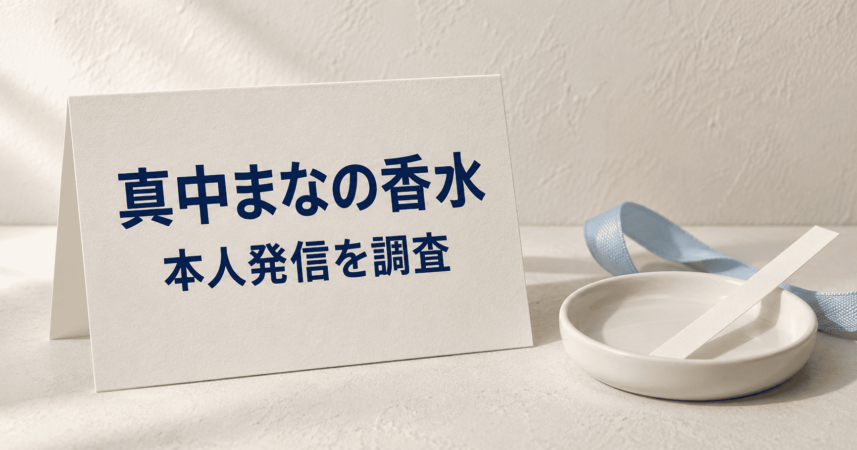 「真中まなの香水 本人発信を調査」と印刷されたカードと水色のリボンの静物イメージ