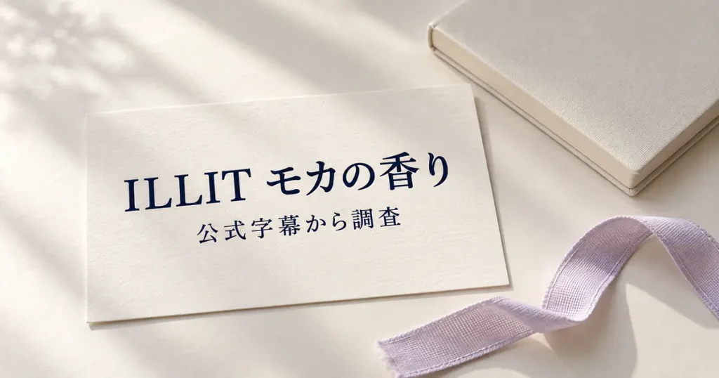 「ILLIT モカの香り」「公式字幕から調査」と印刷されたカードを、淡いラベンダーのリボンとノートのそばに置いた静物イメージ